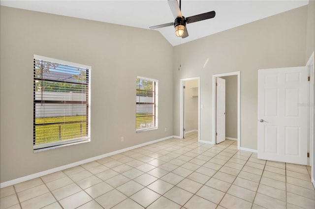 unfurnished bedroom featuring vaulted ceiling, a closet, light tile patterned floors, ceiling fan, and a spacious closet