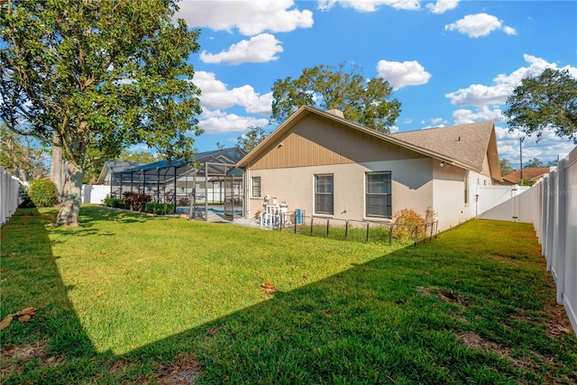 rear view of property with a yard, a fenced in pool, and glass enclosure