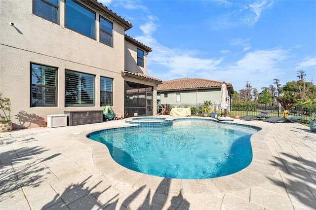 view of swimming pool featuring a sunroom, an in ground hot tub, and a patio