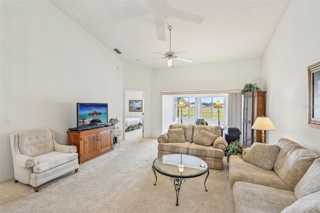 living room featuring high vaulted ceiling, ceiling fan, and light colored carpet