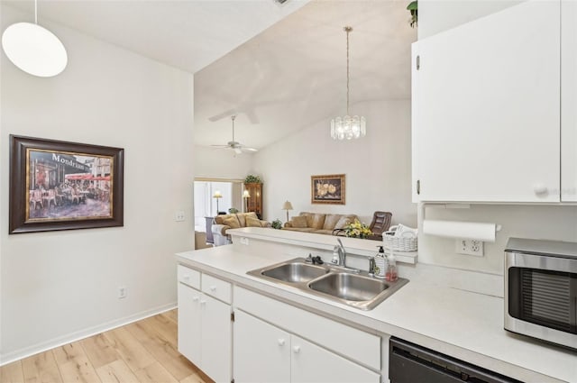 kitchen with sink, white cabinets, dishwashing machine, and pendant lighting