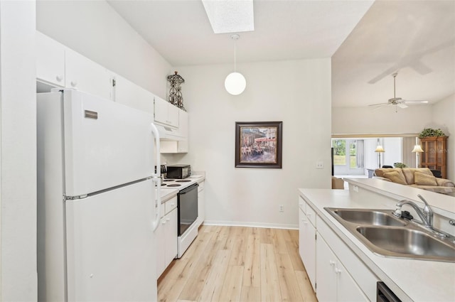 kitchen with sink, decorative light fixtures, white cabinetry, white appliances, and a skylight