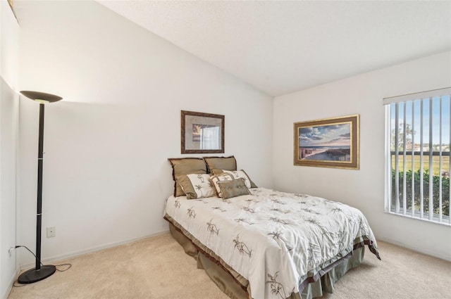 bedroom featuring lofted ceiling and light carpet