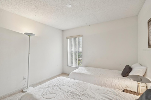 bedroom featuring a textured ceiling and light carpet