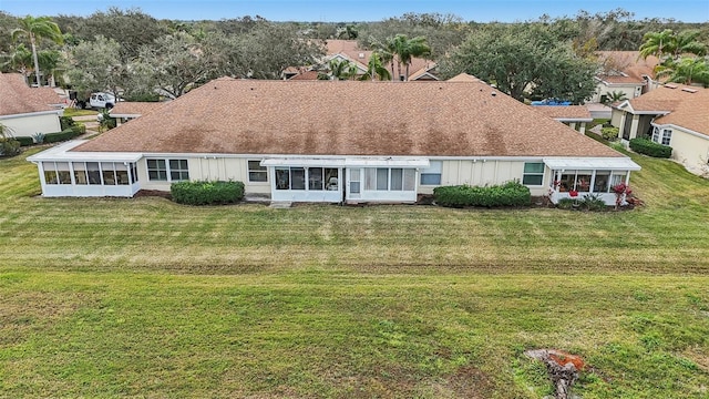 back of property with a yard and a sunroom