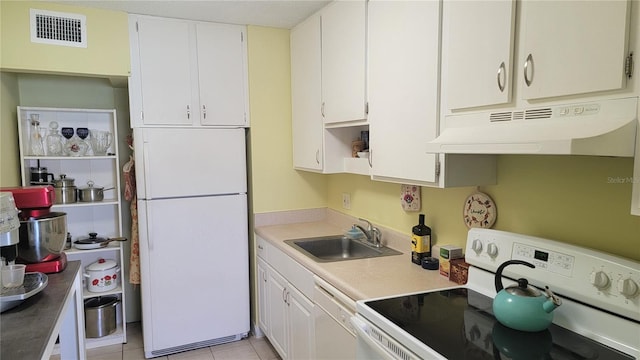 kitchen with white appliances, white cabinetry, sink, and light tile patterned floors