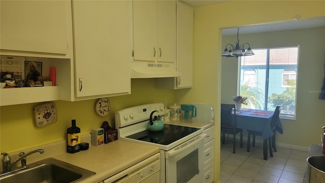 kitchen with sink, white appliances, light tile patterned floors, hanging light fixtures, and a notable chandelier