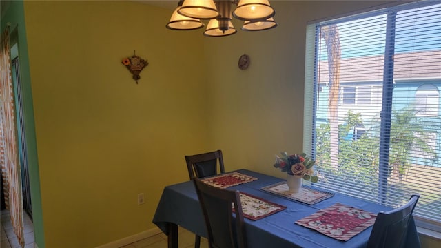 dining space featuring tile patterned flooring and a chandelier