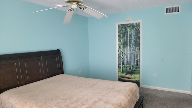 carpeted bedroom featuring a textured ceiling and ceiling fan