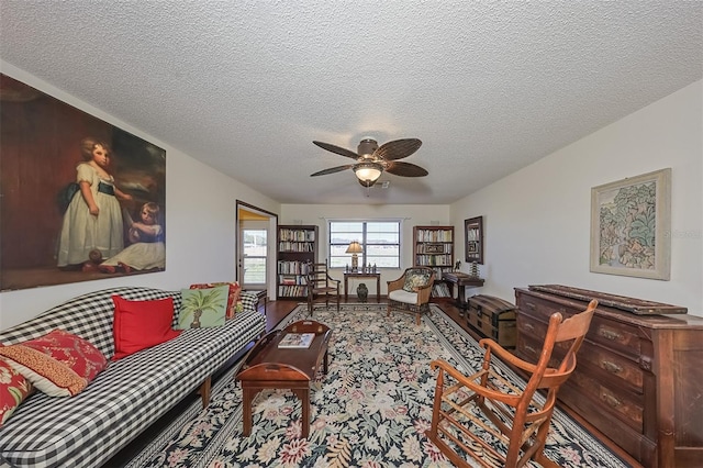 living room featuring ceiling fan and a textured ceiling