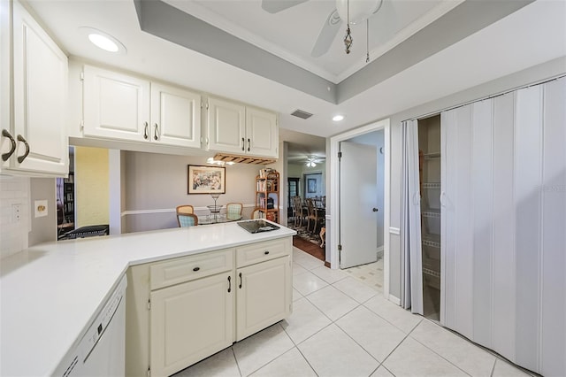 kitchen featuring crown molding, white cabinetry, kitchen peninsula, a raised ceiling, and ceiling fan