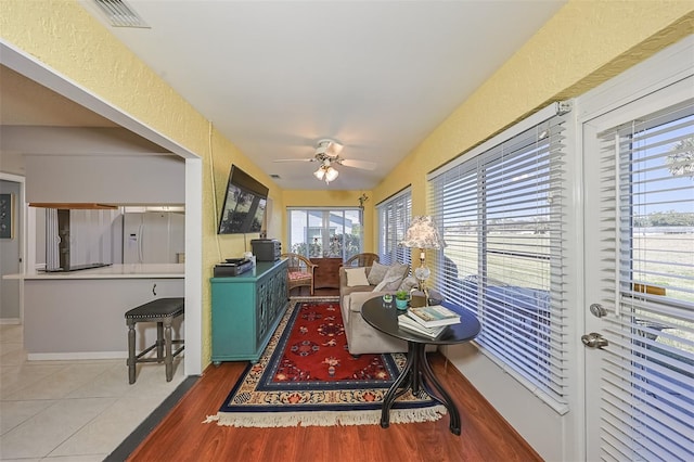 living room with tile patterned flooring and ceiling fan