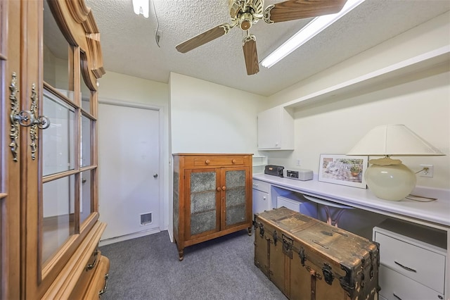 interior space with ceiling fan, a textured ceiling, and dark colored carpet