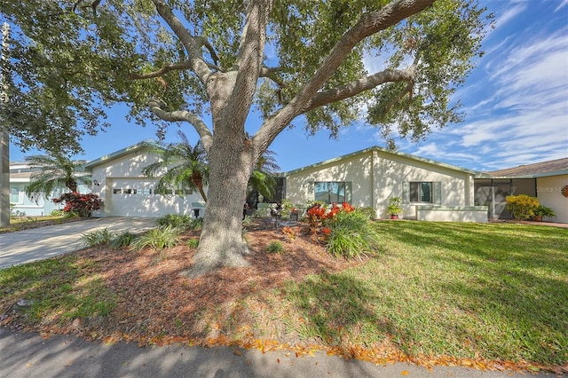 ranch-style home featuring a garage and a front lawn