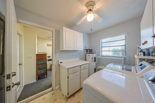 clothes washing area featuring water heater, ceiling fan, washing machine and dryer, cabinets, and a textured ceiling