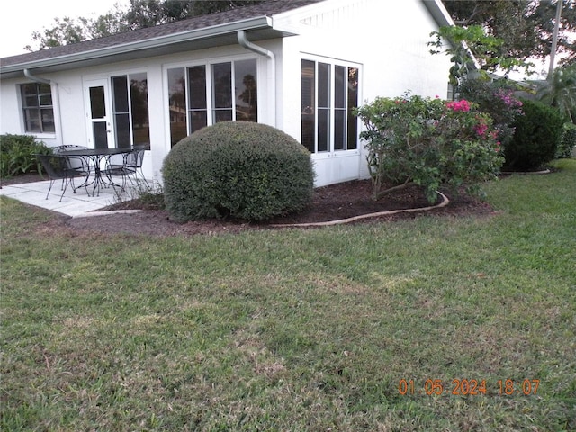 rear view of house with a yard and a patio