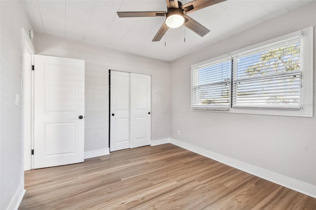 unfurnished bedroom with multiple windows, ceiling fan, a closet, and light hardwood / wood-style floors