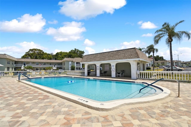 view of pool with an outbuilding and a patio