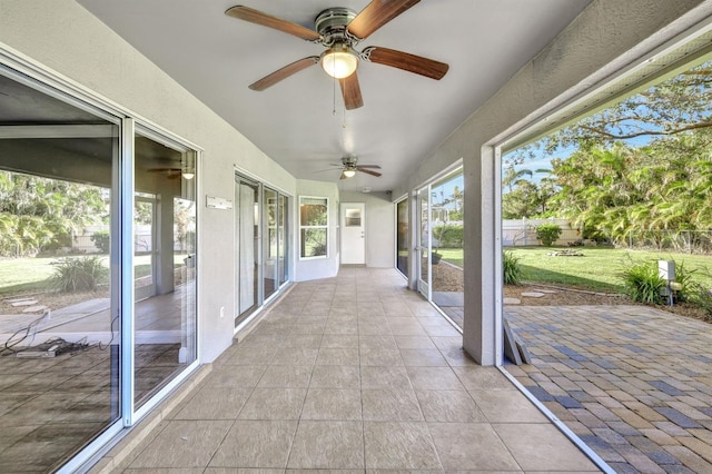 unfurnished sunroom featuring ceiling fan