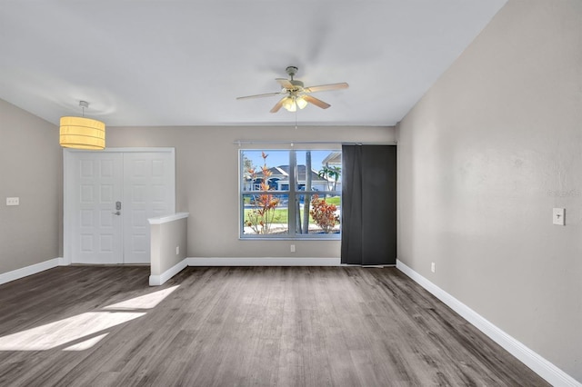 unfurnished living room featuring dark hardwood / wood-style floors and ceiling fan