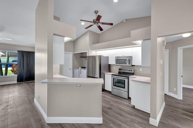 kitchen featuring white cabinetry, light hardwood / wood-style flooring, independent washer and dryer, kitchen peninsula, and appliances with stainless steel finishes