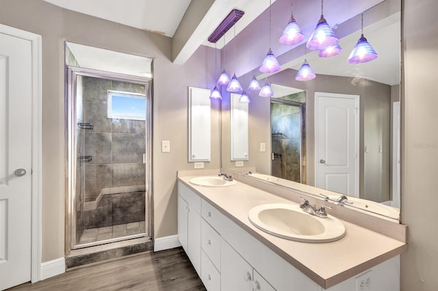 bathroom with hardwood / wood-style floors, vanity, and an enclosed shower