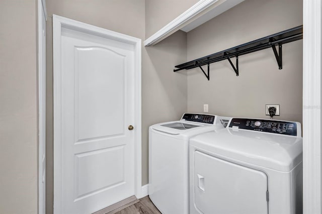 laundry area featuring independent washer and dryer and light hardwood / wood-style flooring