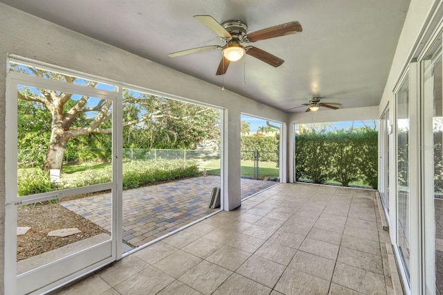 unfurnished sunroom with ceiling fan