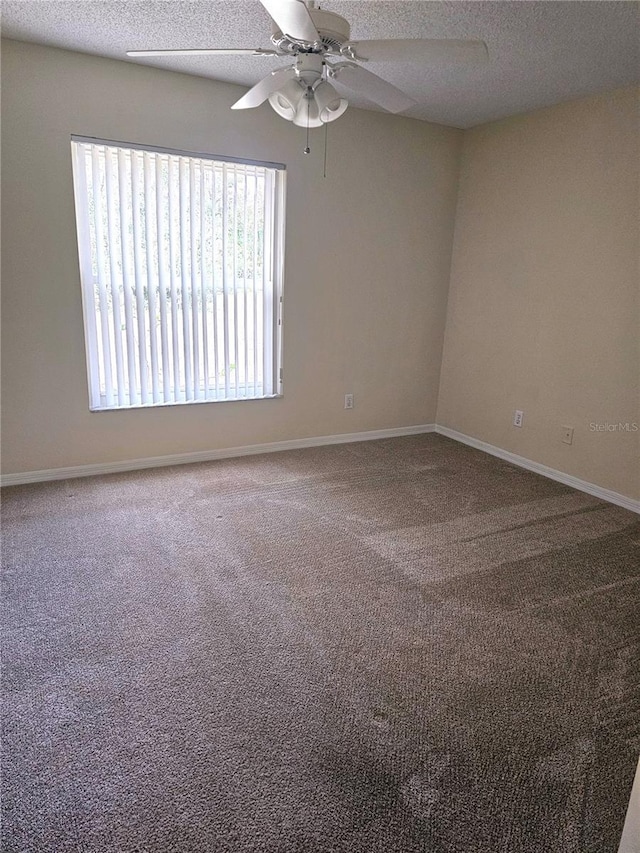 spare room featuring ceiling fan, carpet floors, and a textured ceiling