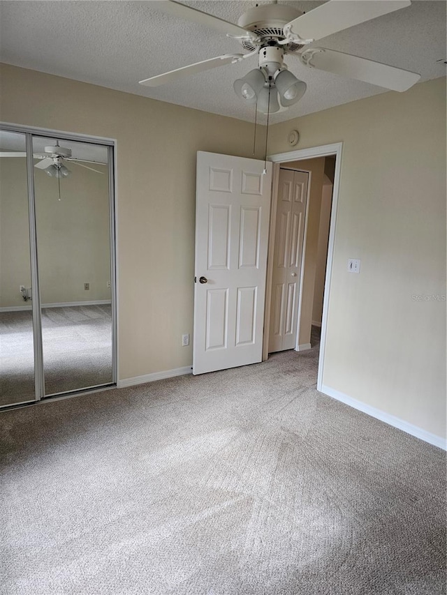 unfurnished bedroom with carpet floors, a textured ceiling, ceiling fan, and a closet