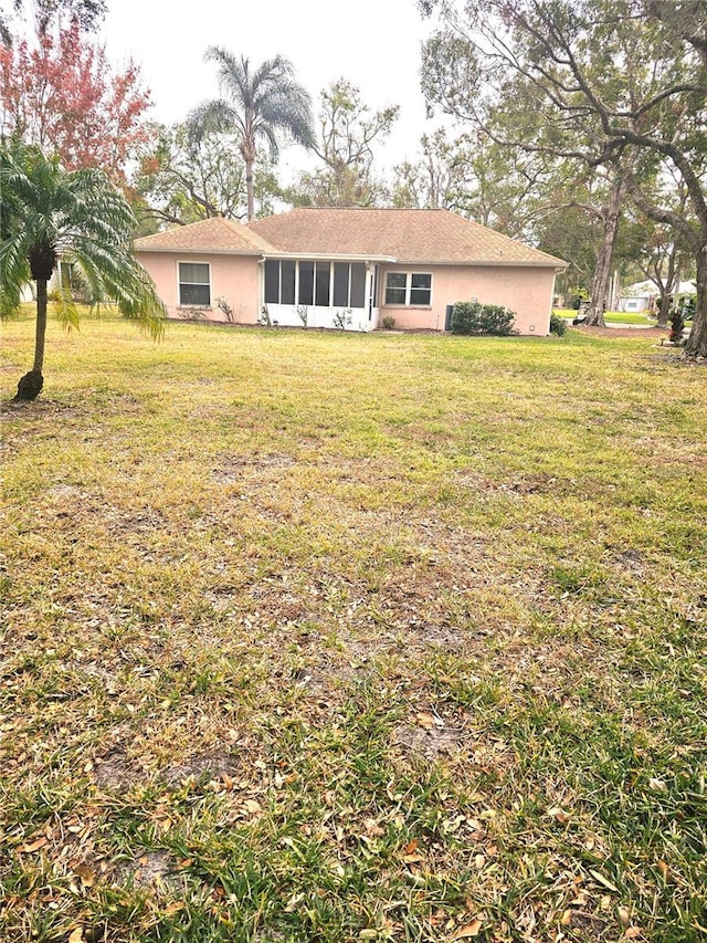 exterior space featuring a sunroom and a yard