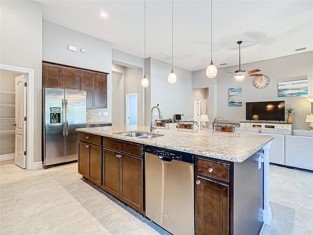 kitchen featuring sink, hanging light fixtures, dark brown cabinets, a kitchen island with sink, and appliances with stainless steel finishes