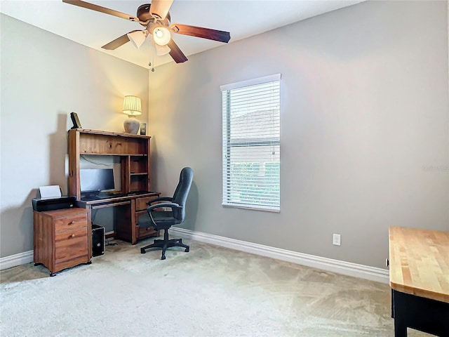 carpeted home office featuring ceiling fan