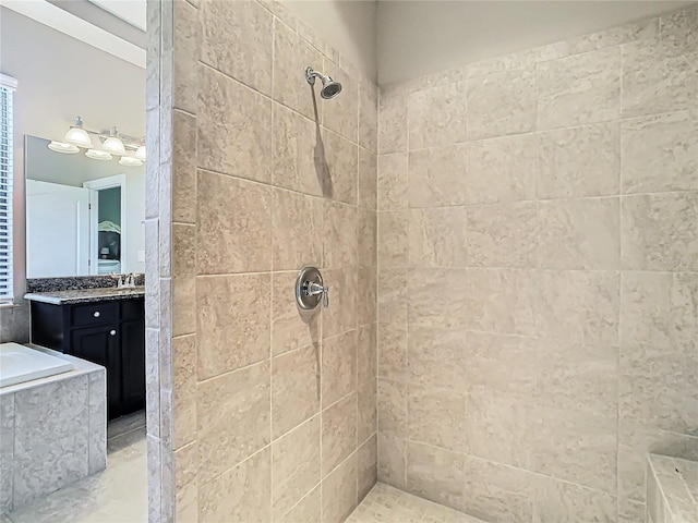 bathroom featuring tiled shower and vanity