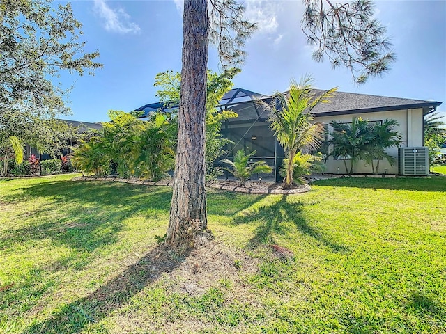 view of yard with a lanai and central AC