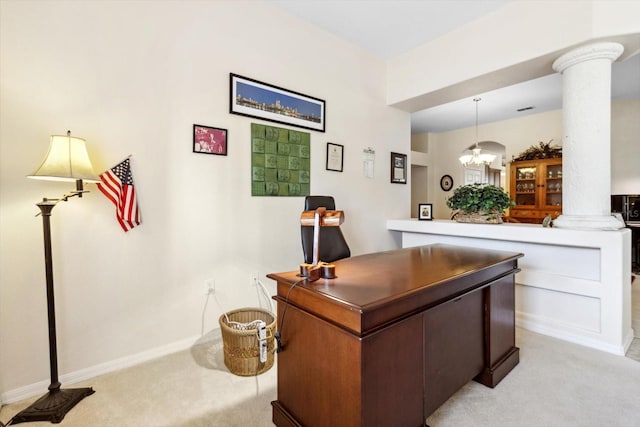 carpeted office space featuring decorative columns and a chandelier