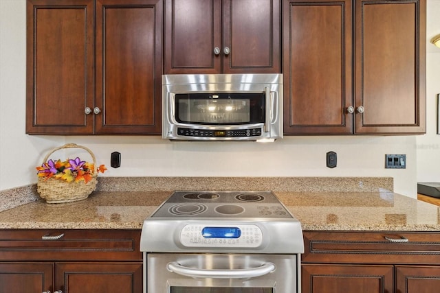 kitchen featuring light stone counters and stainless steel appliances