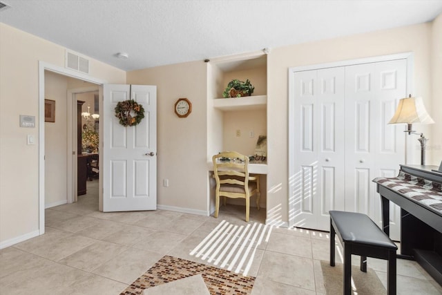 miscellaneous room with light tile patterned floors and a textured ceiling