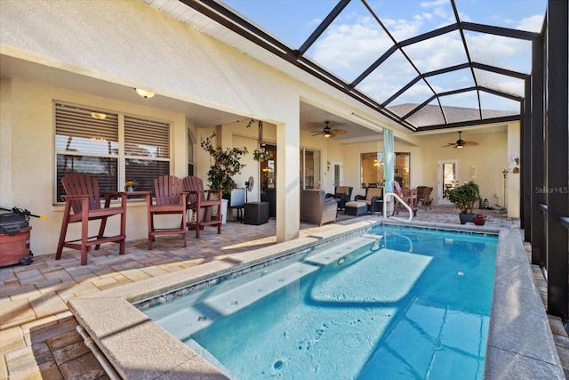 view of swimming pool with glass enclosure, a patio area, ceiling fan, and an outdoor hangout area