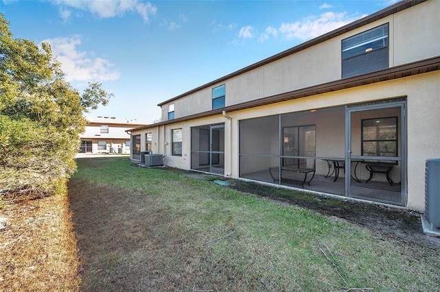 rear view of house with a patio, central AC unit, and a yard