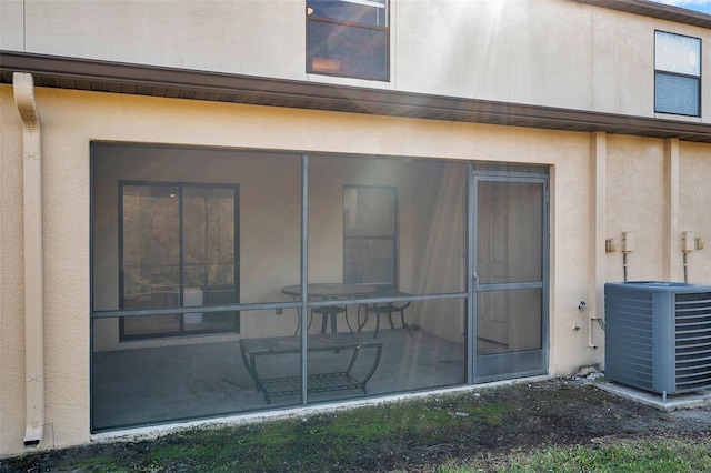 back of property featuring central AC and a sunroom