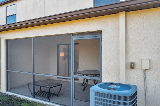 view of patio / terrace with a sunroom and central AC unit