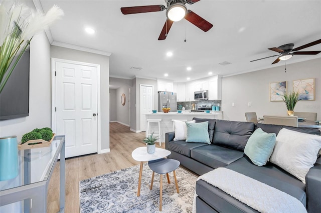 living room with ornamental molding and light hardwood / wood-style flooring