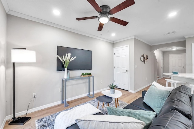 living room with ornamental molding, ceiling fan, and light hardwood / wood-style floors