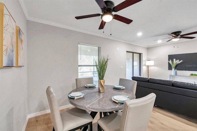 dining room with light hardwood / wood-style floors and crown molding