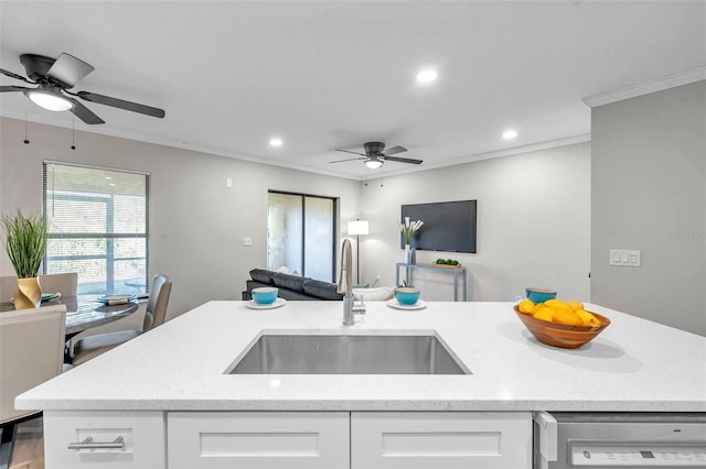 kitchen with light stone countertops, stainless steel dishwasher, crown molding, white cabinets, and sink