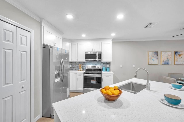 kitchen featuring white cabinets, appliances with stainless steel finishes, backsplash, and sink