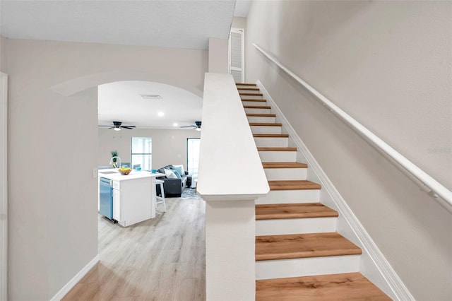 stairway featuring sink, hardwood / wood-style floors, and ceiling fan