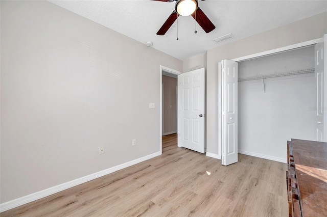 unfurnished bedroom featuring light wood-type flooring, ceiling fan, and a closet