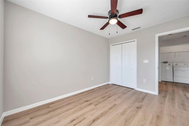 unfurnished bedroom with light hardwood / wood-style floors, ceiling fan, and separate washer and dryer